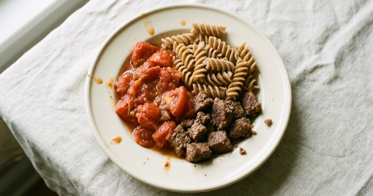 Whole-wheat pasta with beef and tomato β beef, whole-wheat pasta, tomato on a plate built around the Harvard Healthy Eating Plate